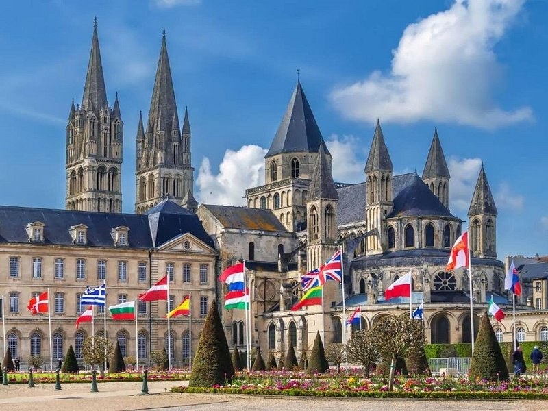 The abbey church and town hall of Caen behind a row of flags