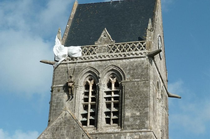 A village church in the Cotentin with a paratrooper figure hanging from its tower